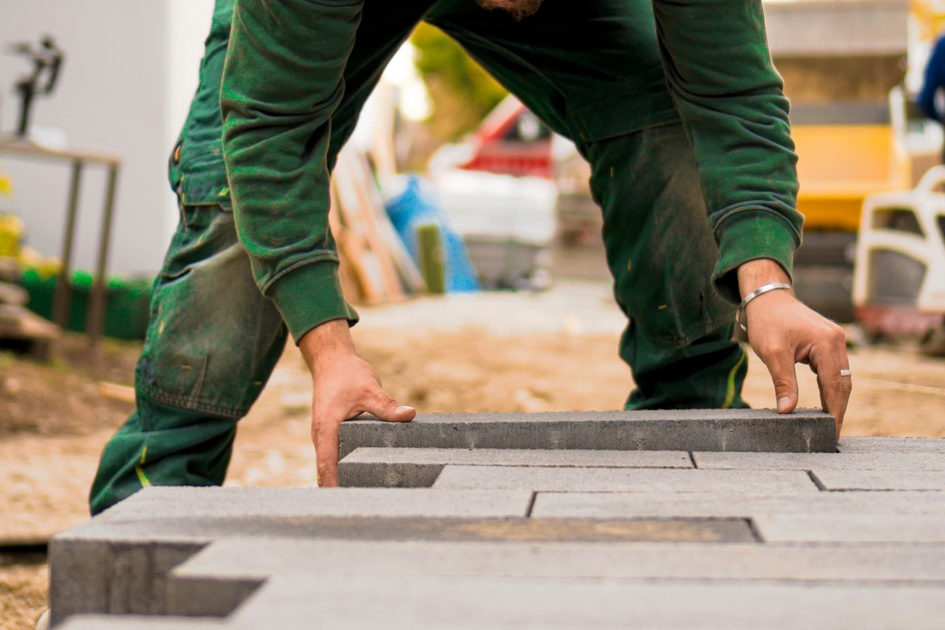 Handwerker beim Verlegen von Pflastersteinen im Außenbereich